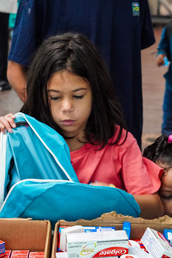 Child receiving a backpack and gift card at The Greatest Commandment Inc. Back-to-School Outreach in Orlando 2024.