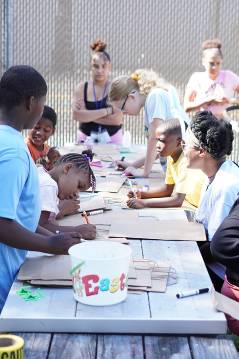 Volunteer handing Easter basket to homeless child during The Greatest Commandment Inc. Easter Event in Orlando.