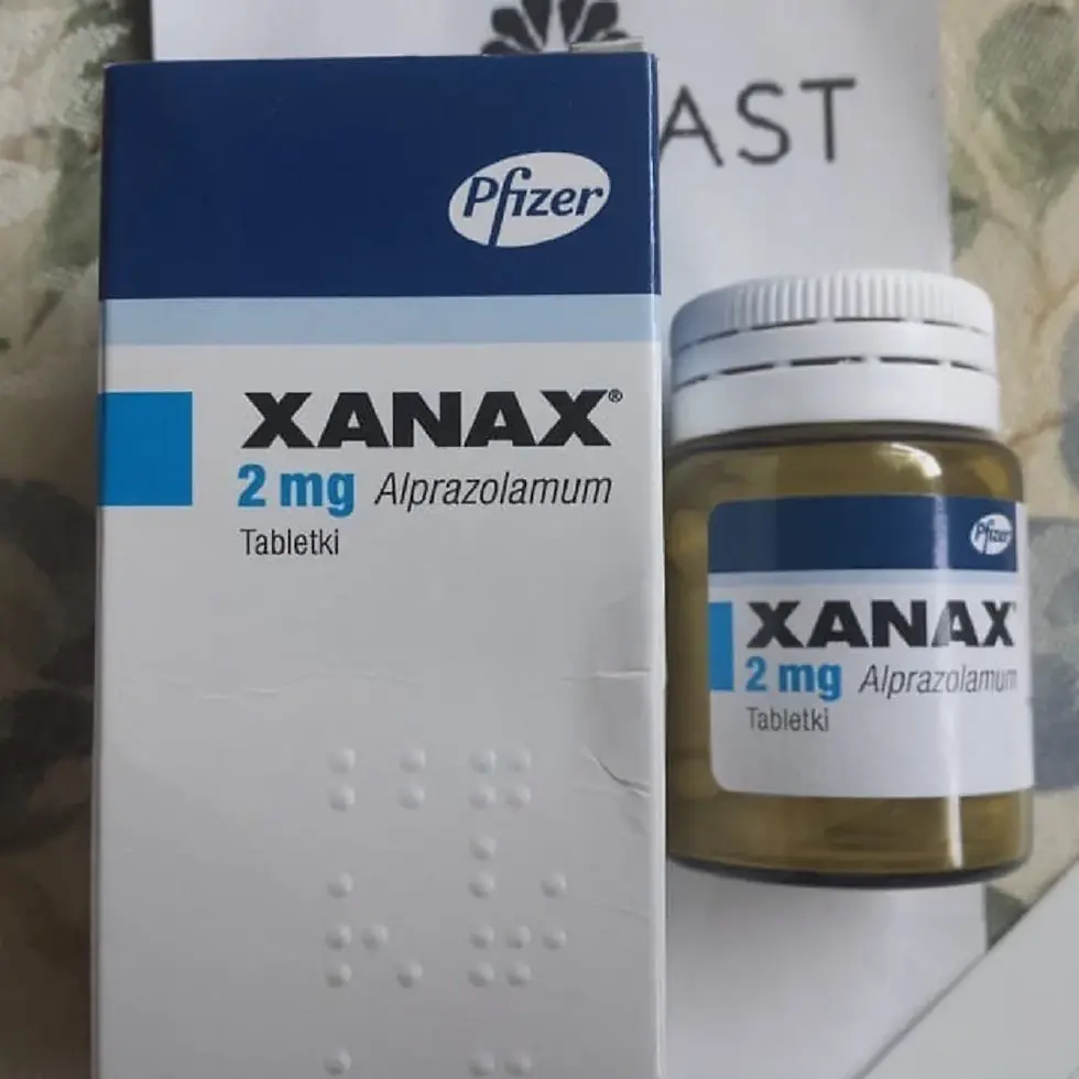 Pfizer Xanax 2 mg alprazolam box and pill bottle on a patterned surface, with Polish text Tabletki visible.