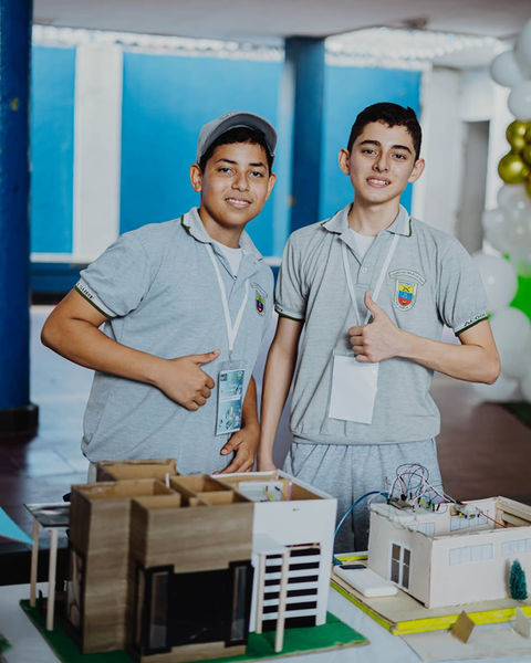 Dos estudiantes orgullosos muestran modelos arquitectónicos. Inicio. Colegio Militar Acoolsure.