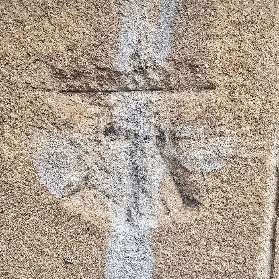 A photo of a benchmark carved into the wall of an old building.