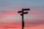 guide post with a sunset in the background