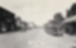 Exmore Street Scene of early 1900's. Cars line the dirt street and people bustle about the shops.