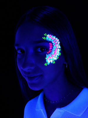 Portrait d’une femme avec maquillage néon fluorescent et motifs violets sous lumière noire