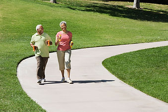 Two women walking together on a sunny path