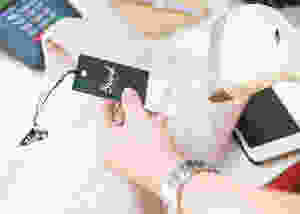 Woman scanning the barcode on the price tag of a sweater in a retail store