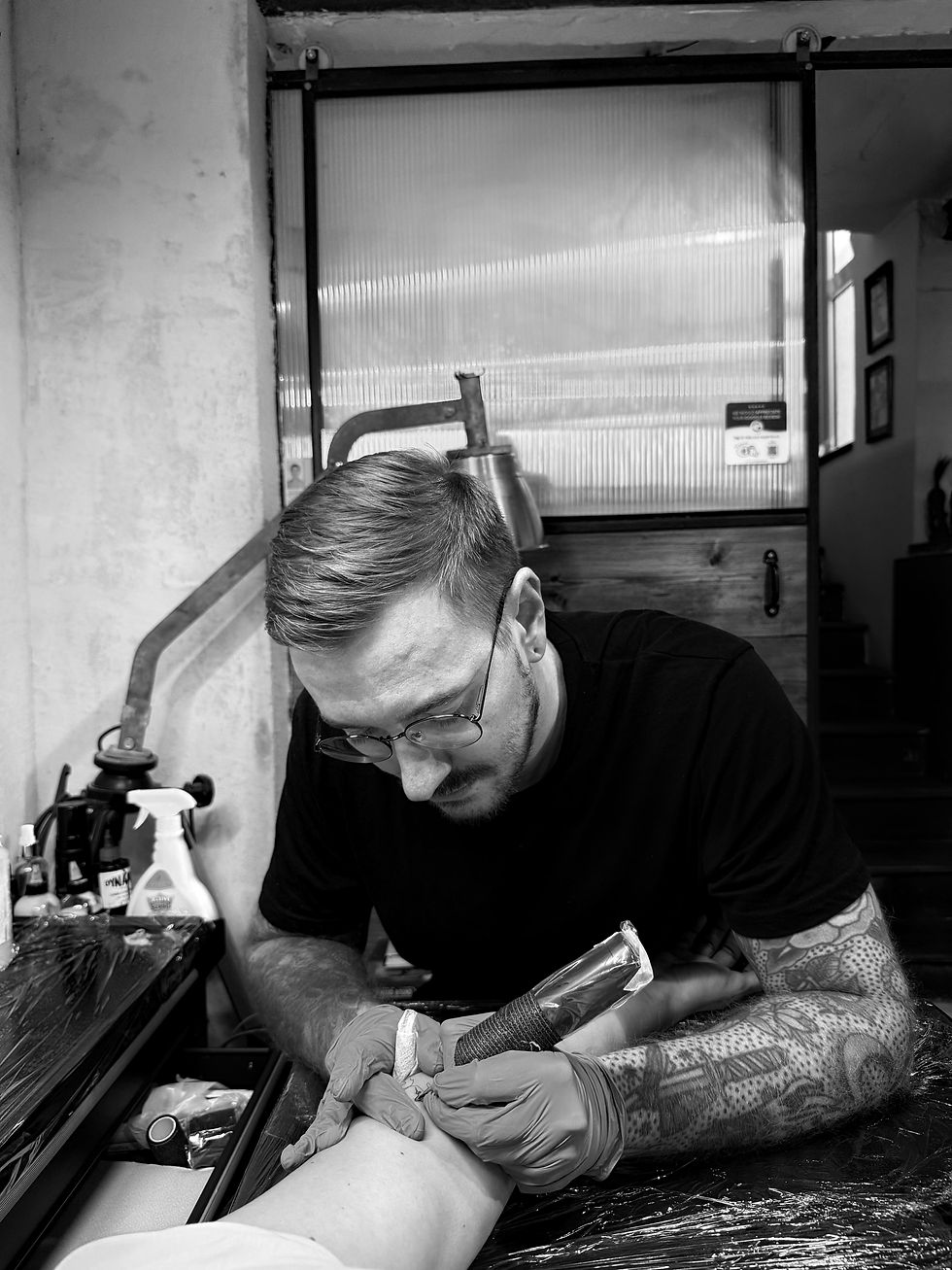 Tattoo artist in Malta sketching black geometric sleeve before inking.