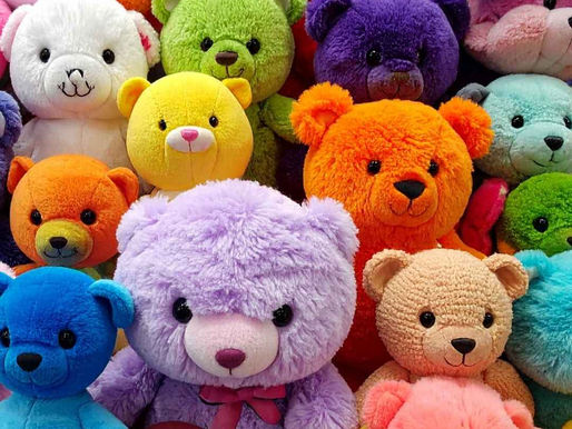 A collection of colorful teddy bears in vibrant hues like purple, orange, and blue, with some smiling expressions, creating a cheerful scene.
