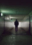 Person walking alone through dimly lit underpass