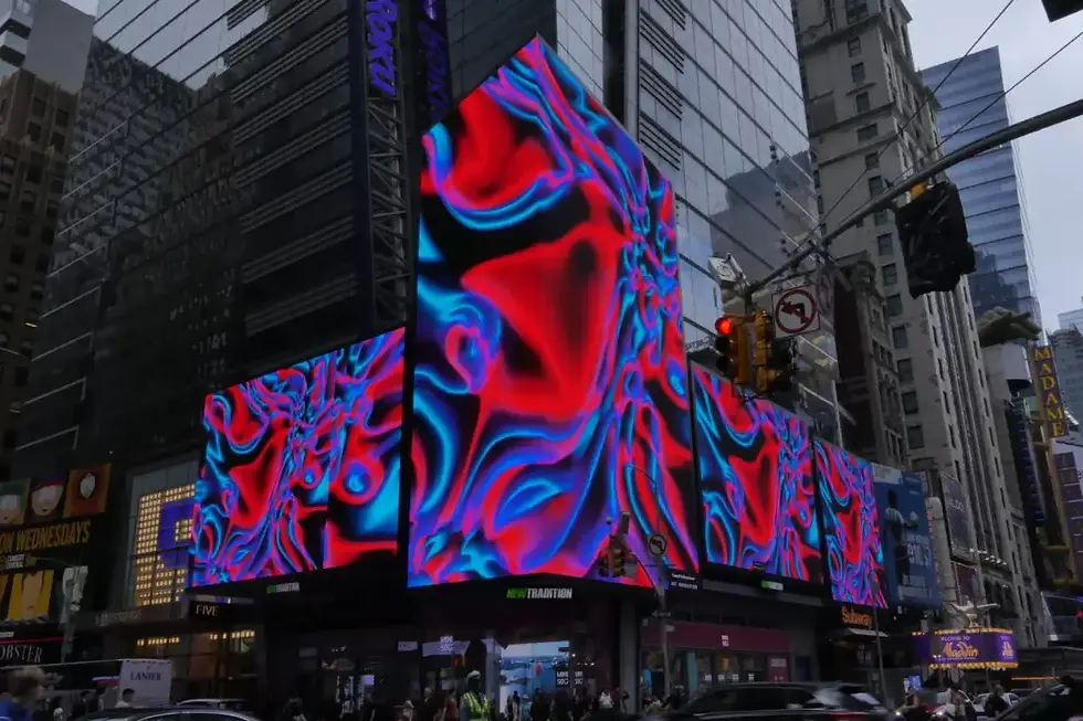 Cromwell’s digital artwork Neon Coral displayed on multiple LED billboards in New York’s Times Square, featuring flowing red and blue abstract patterns that ripple across the building fronts against the city skyline.