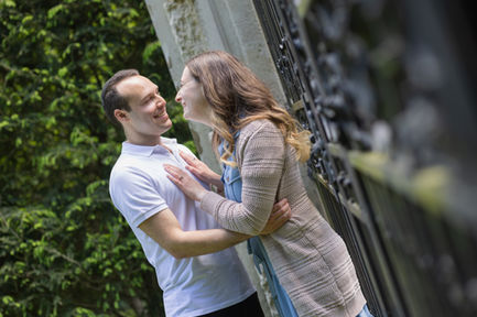 Couple dancing playfully outdoors at Westbury Gardens, smiling and gazing into each other's eyes.