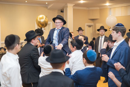 a boy in a suit and tie is being lifted in the air