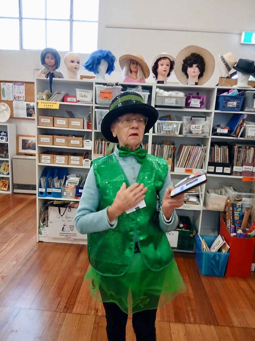 Person in green costume with a hat holding a book