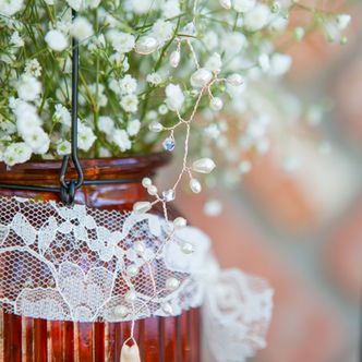 White baby's breath in amber glass jar with lace