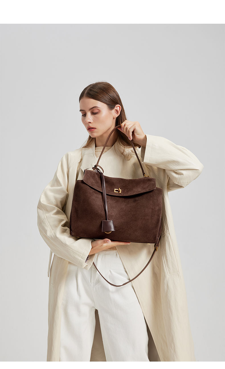 Thumbnail: Dark Brown Heritage Suede Leather Tote Bag – Premium Edition carried by the model.