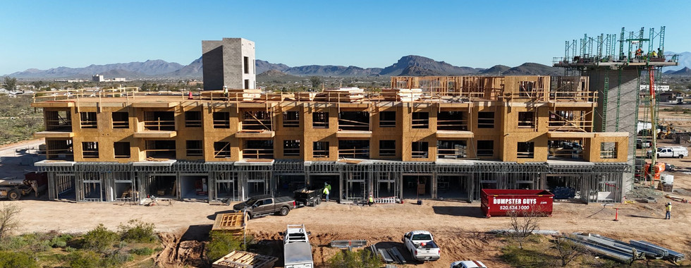 Wide shot of construction progress of apartment building with scenic mountain range in bacckground