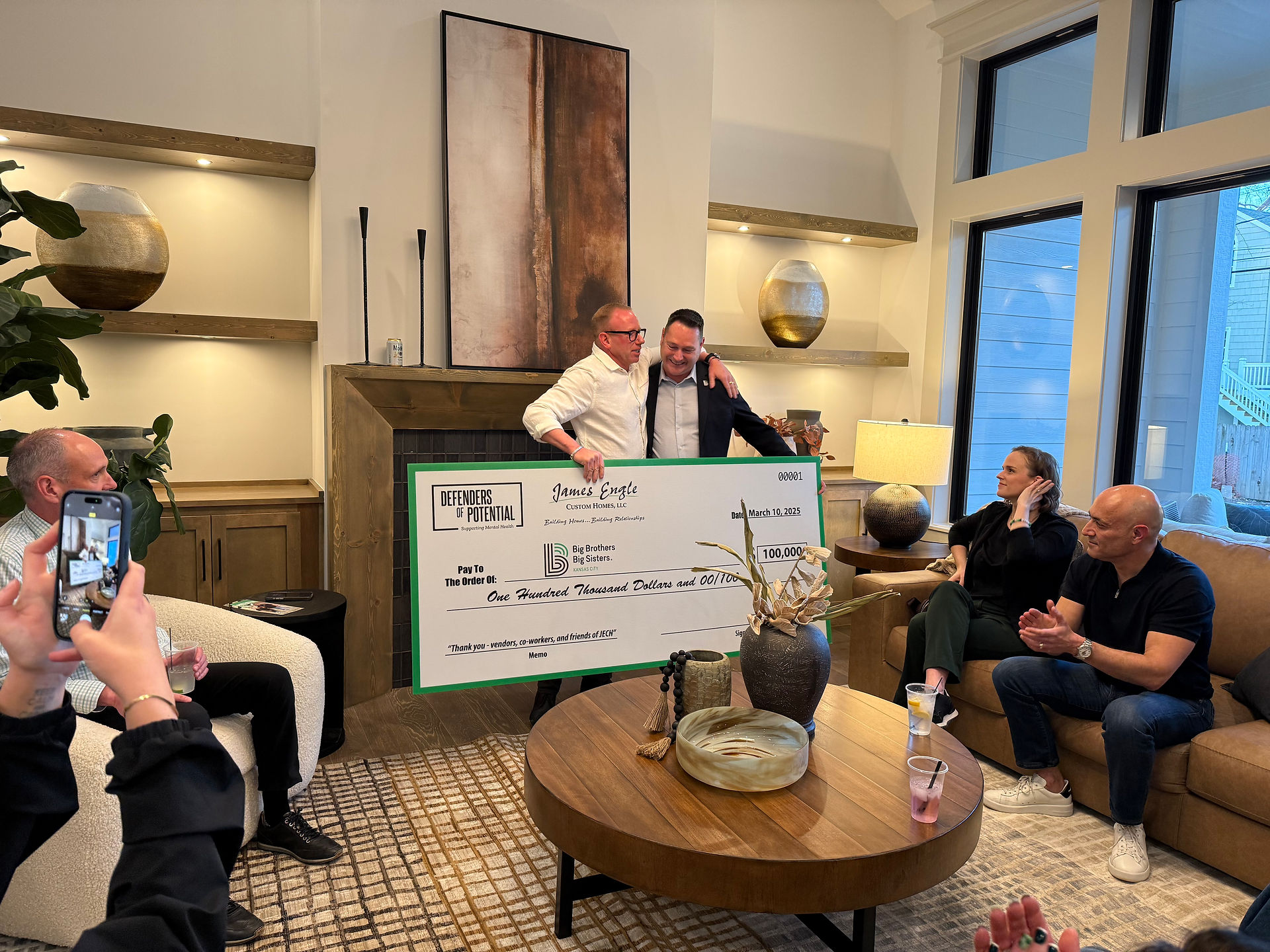 Photo holding up giant check for proceeds of sale of house to benefit Big Brother Big Sisters Kansas City