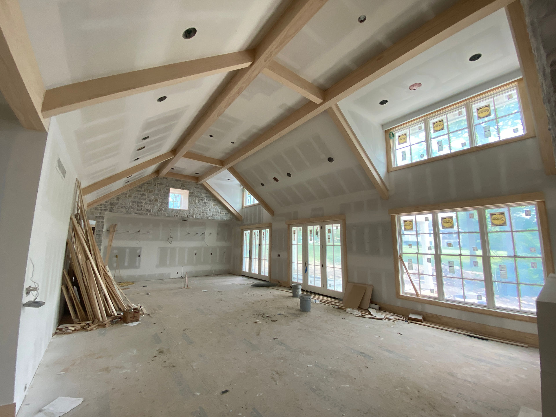Living room with vaulted ceilings and upper-dormer windows under construction