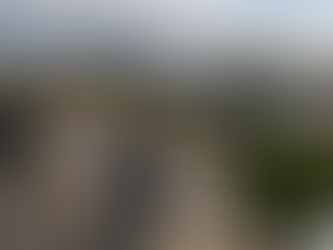 Drone performing a roof inspection over a construction site in Ireland while engineers review inspection data on a tablet.