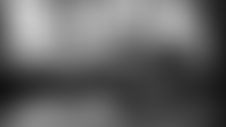 Factory workers seated at workbenches sorting components inside a workshop