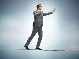 Man walking blindfolded on tightrope