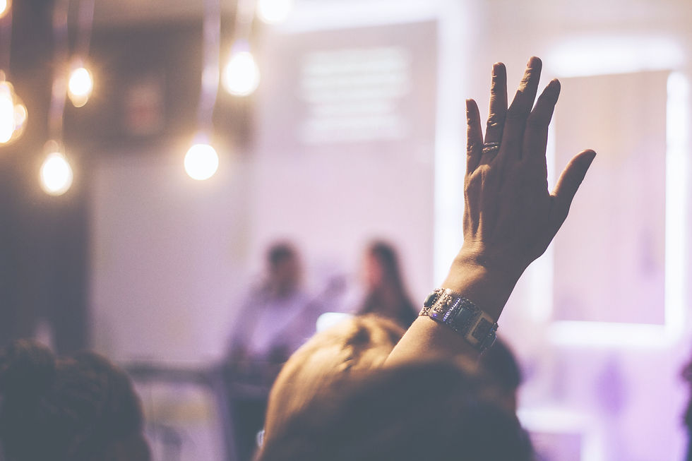 blurred church background with raised hand in the forefront
