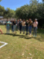 Happy diverse group of young women jumping outdoors on grass.