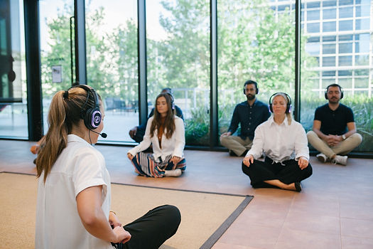 Smile o'clock Maike instructing participants in meditation, back profile of Maike front pr