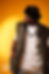 Homme en tenue urbaine posant sur fond jaune.