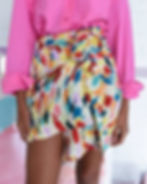 Splashy multicolor brushstroke print on structured wrap skirt – bold abstract surface pattern paired with solid brights.