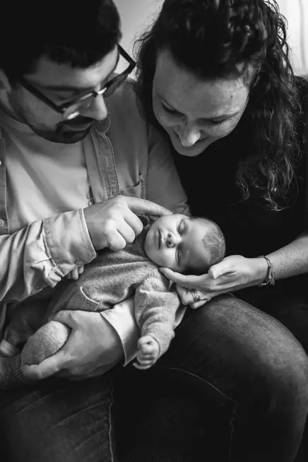 Séance photo naissance en Essonne, moment de douceur entre les parents et leur bébé endormi