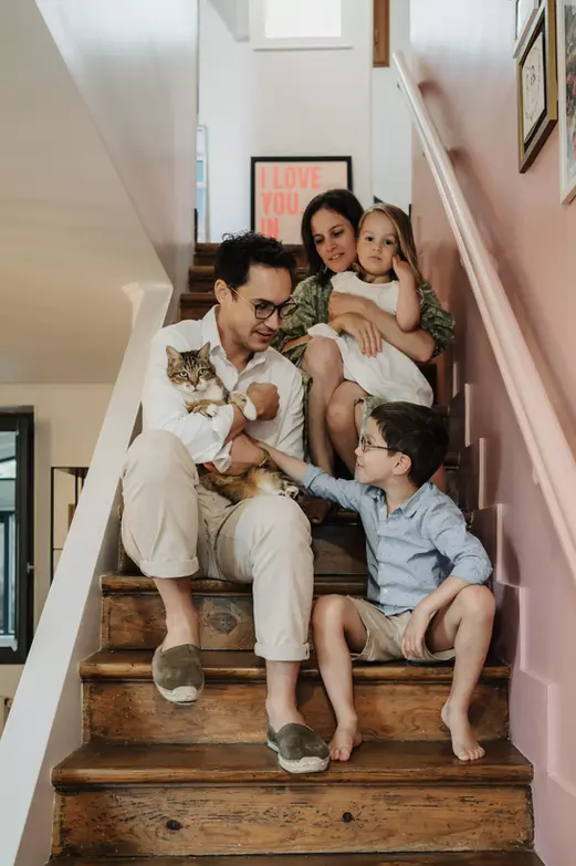 Parents avec leurs enfants et leur chat dans un escalier lors d’une séance photo famille à domicile en Essonne
