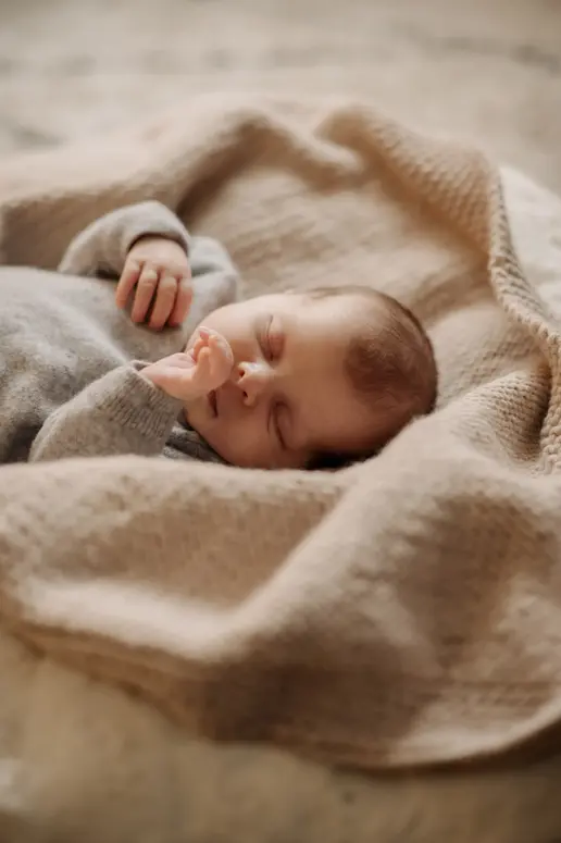 Portrait d'un bébé photographié en lumière naturelle dans une ambiance douce et feutrée