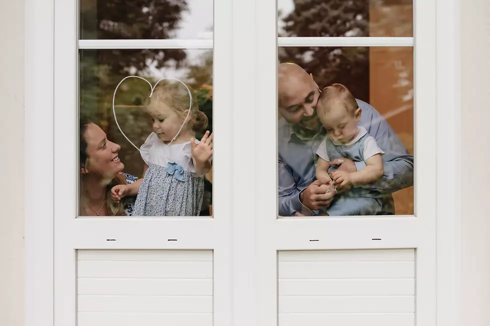 famille photographiée à travers une fenêtre alors qu'elle est en train de dessiner dessus