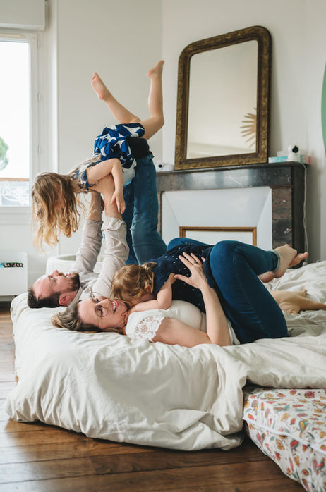 Photo de famille heureuse jouant et faisant des câlins pendant une
séance photo à la maison