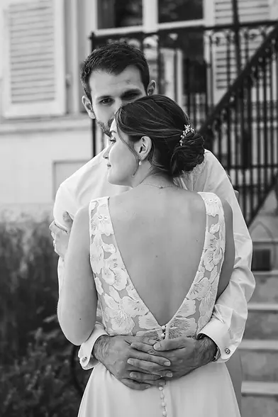 Couple de mariés enlacés photographiés en noir et blanc dans un style élégant et intemporel.