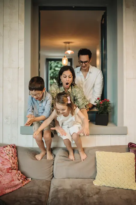 Photo de famille pleine d'humour, jouant ensemble lors d’une séance lifestyle à domicile en Essonne