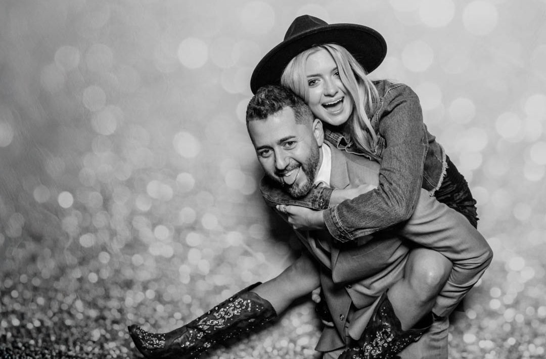 male gives female piggyback ride in photo booth