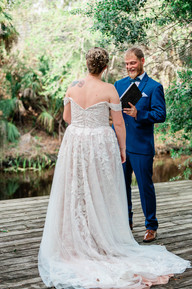 bride and groom exchange wedding vows on deck by creek at chapel creek wedding and events