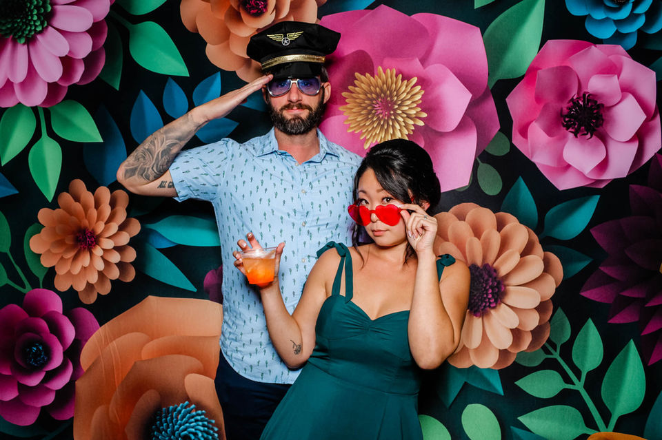 Couple in pilot hat and sunglasses at photo booth