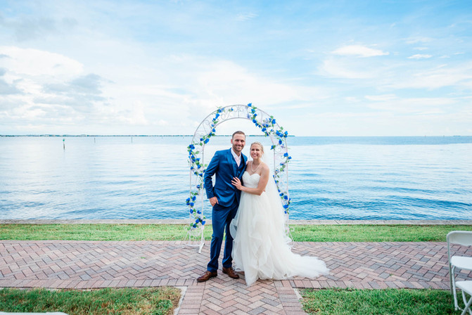 bride and groom pose in front of alter at charlotte harbor yacht club