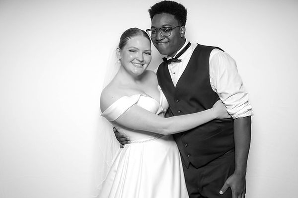 bride and groom pose in black and white glam photo booth with white background