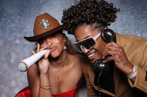 Two women at photo booth, playful poses