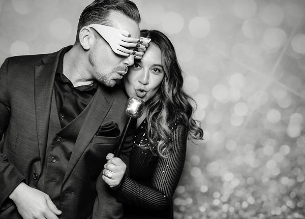 a couple romantically poses in an open air photo booth