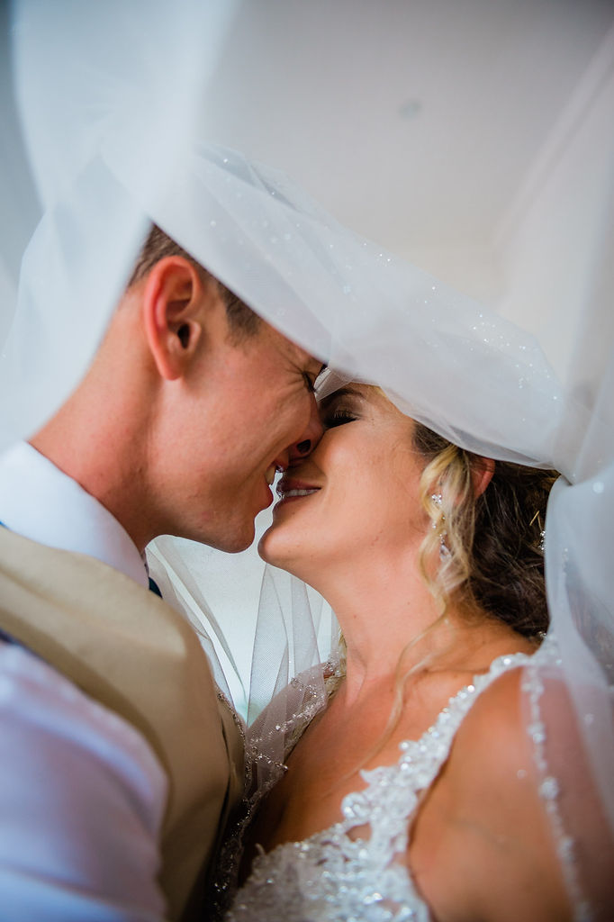 bride and groom kissing under vail, flounders golf club wedding