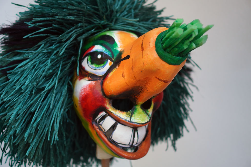 Ein Foto einer Waggis Larve. Aus dem Atelier Charivari in Basel. Klassisch bemalt mit einem Twist: statt der roten Nase ist da eine orange Karotte.