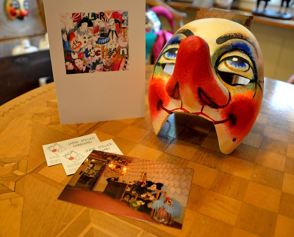 Stimmungsbild: Waggis Gummiband Larve Form Nr. k20, links daneben ein Larven Atelier Charivari Gutschein.