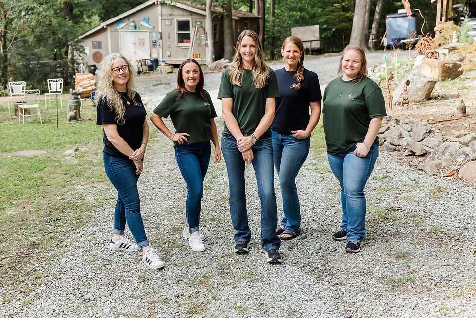 Group of women standing together in green tees and jeans