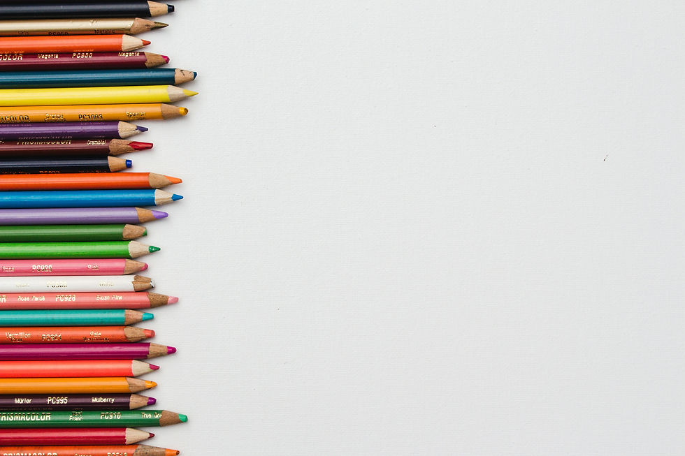 A blank cream canvas with multi-colored, sharpened pencils lined up, pointing from the left.