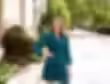 Woman in dark green dress with hand on hip, smiling at camera